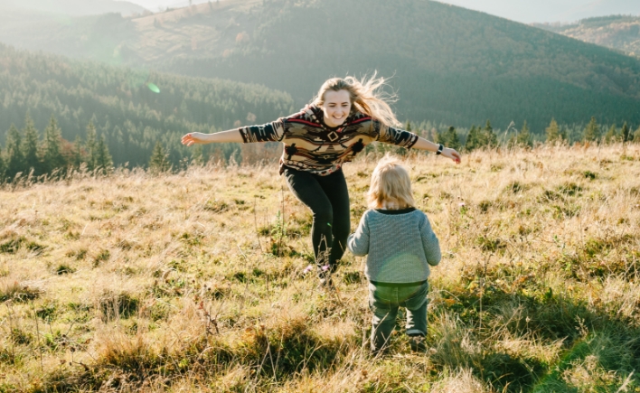 woman and child playing in field